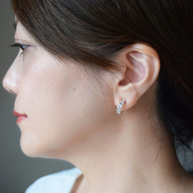 シルバー925製ツイストフープイヤリング「Rope」を着用した女性モデルの横顔写真。日常のオフィスやデイリーシーンにも馴染むサイズ感と、都会的で凛としたピアス風のデザイン。